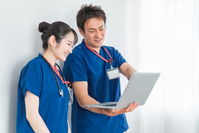 パソコンを見て話す医師と看護師